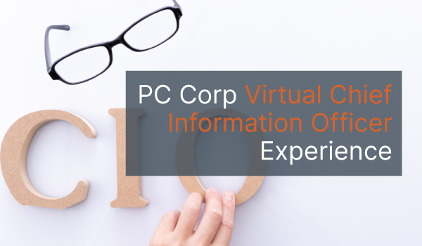 Woman's hand placing the wooden letters CIO on a white surface with the words "PC Corp Virtual Chief Information Officer Experience" overlayed on top.