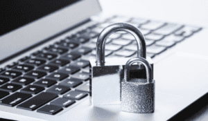 Two padlocks on top of a laptop.