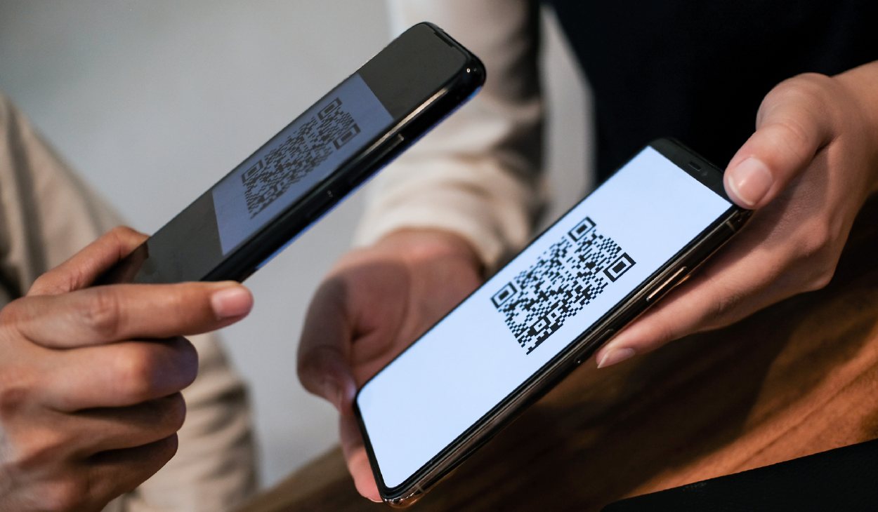 Two people holding mobile devices showcasing QR codes, allowing them to scan and retrieve digital information effortlessly.