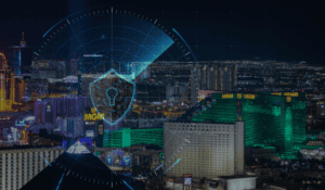 The city of Las Vegas lit up at night, with a cybersecurity shield overlay on the image.
