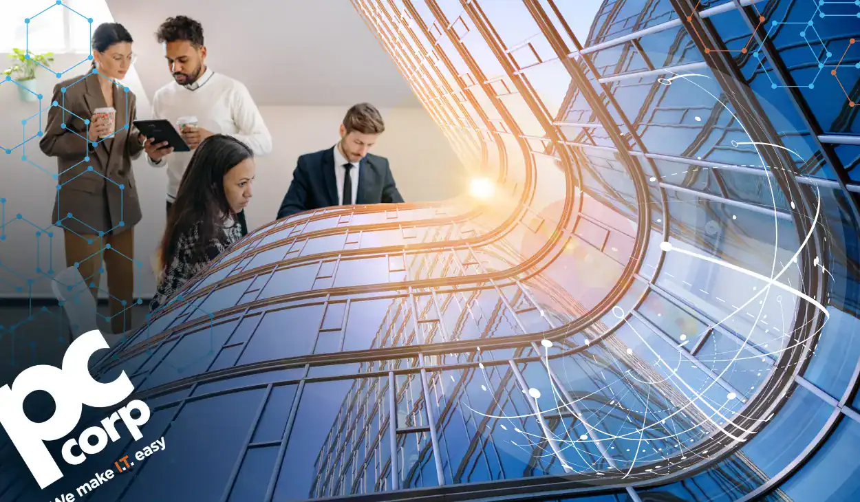 The image represents the blog title and theme: Why Enterprise IT Projects Take 6 Months (And What to Do About It). In the top left corner, there is a group of business people standing in business attire, looking at their tablets. There is a funky design of a wavy office building taking up much of the image. It looks like almost a wavy timeline.